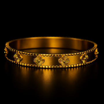 Gold bracelet with floral designs on a black background