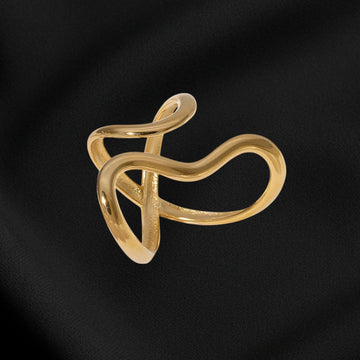 Gold ring with a unique design on a black fabric background