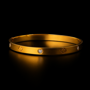 Gold bracelet with engraved designs on a black background