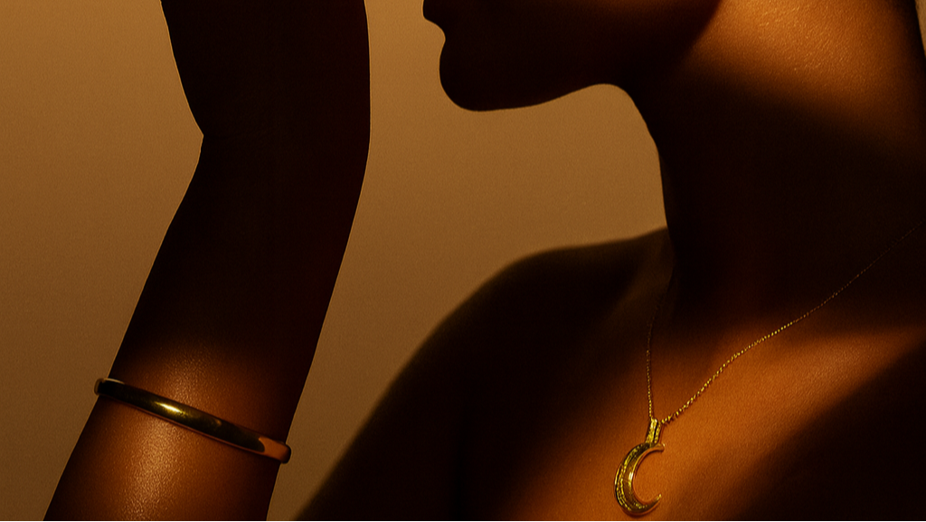 Silhouette of a person wearing gold jewelry against a warm-toned background