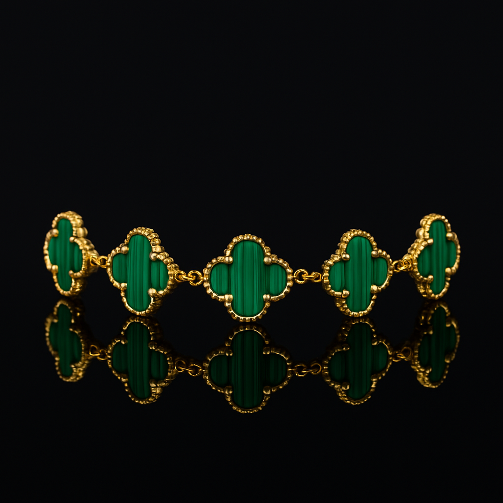 Gold bracelet with green clover-shaped stones on a black background