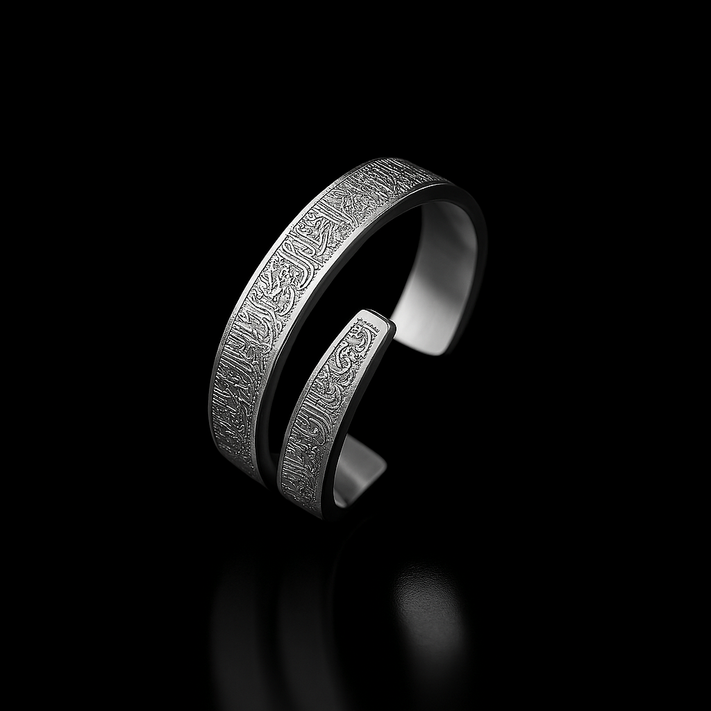 Silver ring with intricate design on a black background