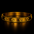 Gold bracelet with floral designs on a black background