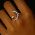 Silver ring with moon and star design on a brown leather surface