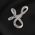 Silver infinity symbol brooch on black fabric
