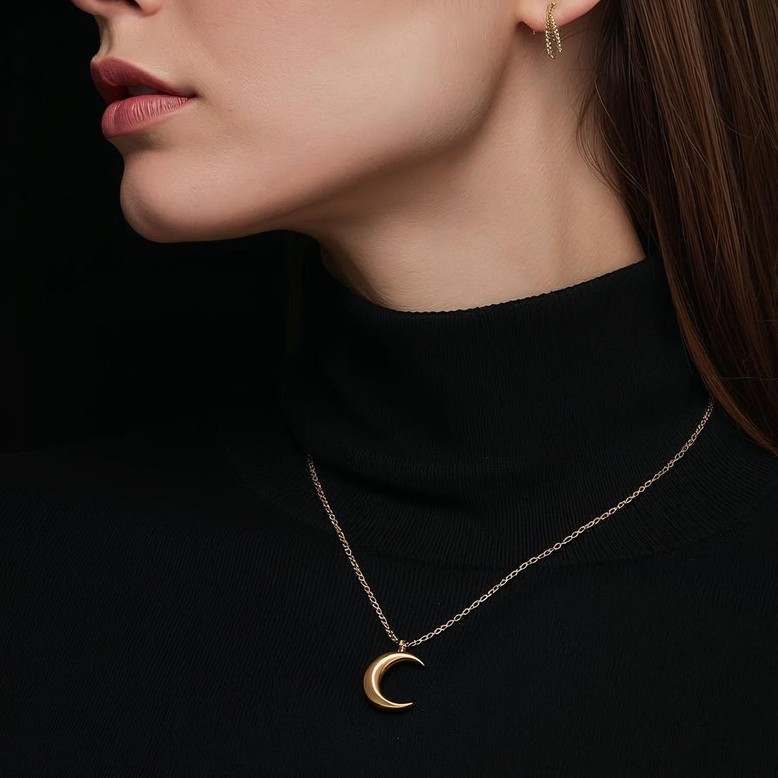 Gold crescent moon necklace on a black background