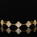 Gold bracelet with clover-shaped links on a black background